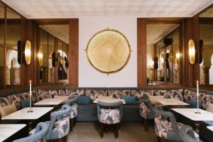 een restaurant met tafels en stoelen en een grote spiegel bij Riad Nyla Wellness and Spa in Marrakesh