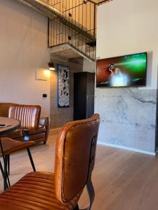 a room with a chair and a tv on a wall at Loft 56 in Porto SantʼElpidio