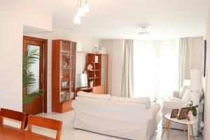 a white living room with a white couch and chairs at Apartamento Dos Valles in Aínsa