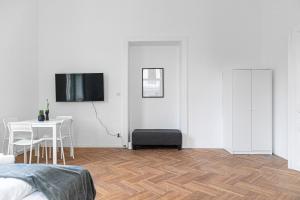 biały pokój ze stołem i telewizorem na ścianie w obiekcie Classy 2BR Apt. w/ Exclusive Location near AKH w Wiedniu