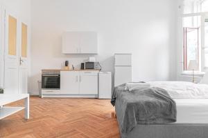 Biały pokój z łóżkiem i kuchnią w obiekcie Classy 2BR Apt. w/ Exclusive Location near AKH w Wiedniu