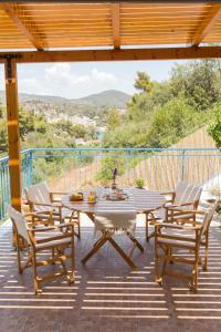 a patio with a table and chairs on a deck at AZALEA - Modern studio with sea view in Galatas