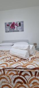 a bed with two towels and a painting on the wall at Appartamento Centro Niscemi in Niscemi