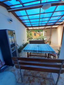 a patio with a table and a bench under a pergola at CASA IZA in Băile Herculane +20 photos