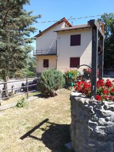una casa con una pared de piedra y flores en Affittacamere La Casa di Alma, en Roncobillaccio