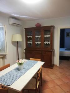 a dining room with a table and a cabinet with wine glasses at Borgo Antico in Montemarciano