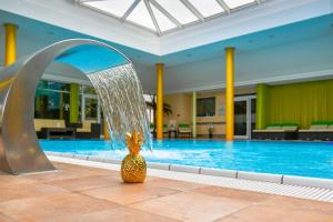 a pineapple statue sitting in front of a swimming pool at Best Western Plus Parkhotel & Spa Cottbus in Cottbus