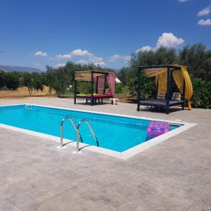 a swimming pool with a gazebo next to at Eco Glamping with Pool between Nafplio and Argos in Argos