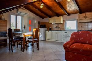 a kitchen and dining room with a table and chairs at Apartman Bella vista in Veli Iž