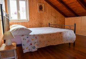 ein Schlafzimmer mit einem Bett in einem Holzzimmer in der Unterkunft Apartman Bella vista in Veli Iž