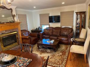 a living room with leather furniture and a fireplace at Come As You Are Inn LLC 