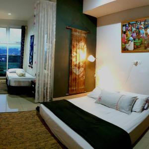 - une chambre avec un lit et une fenêtre avec vue dans l'établissement 1010 - Bohemian Apartment, à Bandung