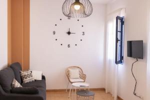 een woonkamer met een klok aan de muur bij Precioso apartamento en Lanzarote, zona Arrecife - El Charco de San Ginés in Arrecife