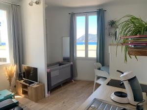 ein Wohnzimmer mit einem TV und einem Schreibtisch in der Unterkunft Studio le Monroe les pieds dans l'eau 10 m de la mer in La Seyne-sur-Mer
