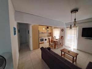 sala de estar y cocina con sofá y mesa en Periklis House, en Ixia