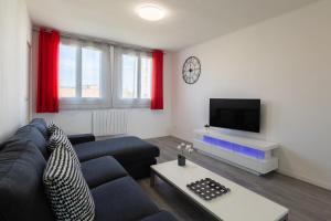een woonkamer met een bank en een tv bij Massilia Holidays in Marseille
