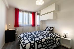 een slaapkamer met een zwart-wit bed en rode gordijnen bij Massilia Holidays in Marseille