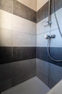 een badkamer met een douche met blauwe en grijze tegels bij Massilia Holidays in Marseille