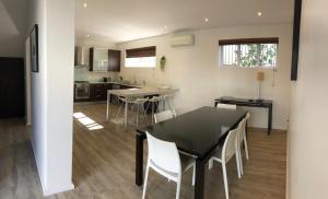 a kitchen and dining room with a black table and white chairs at Milford House in Cape Town