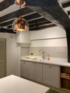 a kitchen with white cabinets and a ceiling at 6 St Peter's Hill in Stamford