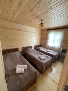 a room with two beds in a log cabin at Warm House in Stepantsminda