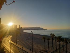 ベニドルムにあるCasa Ainaのヤシの木と夕日の景色を望むビーチの景色