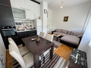 a kitchen and living room with a table and a couch at Jimmy's Apartment in Sarajevo