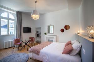 1 dormitorio con 1 cama y 1 mesa con sillas en Confidences Escale à Brissac en Brissac-Quincé
