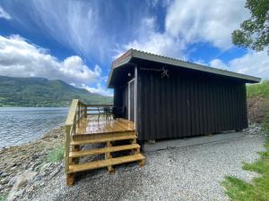 ein Gebäude mit einer Treppe neben einem Wasserkörper in der Unterkunft Fagervik Camping in Tresfjord