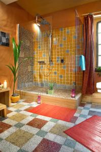La salle de bains est pourvue d'une douche et de carrelage jaune. dans l'établissement La Vieille Maison - Halte Gourmande, à Durfort-et-Saint-Martin-de-Sossenac
