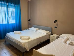 2 camas en una habitación con cortinas azules en B&B Dal Pres, en Bagnara Calabra