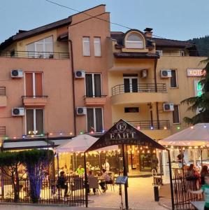 a restaurant with tables and umbrellas in front of a building at Hotel Elit in Devin