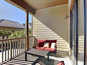 蓝山海滩Redfish Village #M1-218的阳台的门廊配有沙发和桌子