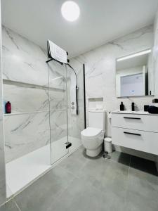 y baño blanco con ducha y aseo. en Apartamento Parque Jardín, en Las Palmas de Gran Canaria