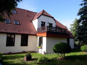 ein großes weißes Haus mit rotem Dach in der Unterkunft Marka Pokoje Gościnne in Mielno