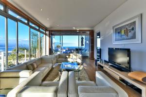 a living room with couches and a flat screen tv at Penthouse 230m2 on the Sea in Plettenberg Bay
