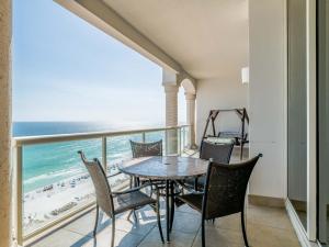 a balcony with a table and chairs and the beach at Beach Club #1605C in Pensacola Beach