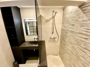 a bathroom with a shower and a sink and a mirror at Le Sable Doux 8D in Middelkerke