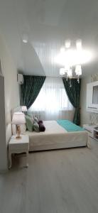 a bedroom with a large bed and a window at Тиффани апартаменты in Dnipro