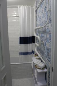 a bathroom with a blue and white shower curtain at Тіффані Апартаменти in Dnipro