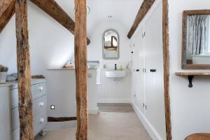 een badkamer met witte muren en houten balken bij Blenheim Cottage, Beautiful 15th Century Cotswold Cottage, 4 Bed, Nr Chipping Campden in Mickleton