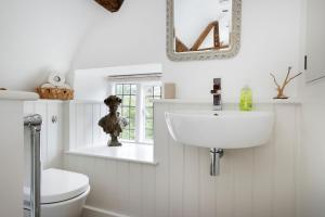 Baño blanco con lavabo y aseo en Blenheim Cottage, Beautiful 15th Century Cotswold Cottage, 4 Bed, Nr Chipping Campden en Mickleton