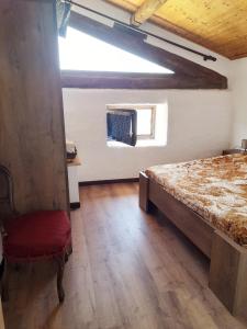 ein Schlafzimmer mit einem Bett, einem Stuhl und einem Fenster in der Unterkunft Baita Martin da Fist in Caderzone
