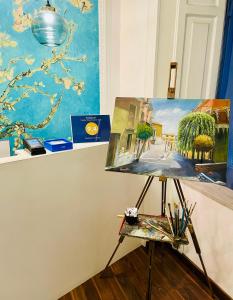 a painting on a stand next to a painting on a wall at RarityArt GuestHouse in Salerno