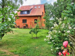 una casa de ladrillo con un patio con rosas en Ferienwohnung Leni, en Walsrode
