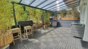 a patio with a solarium with chairs and a grill at City Apartment Hanau in Hanau am Main