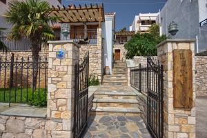 ein Tor zu einem Haus mit einem Steinzaun in der Unterkunft PETRINO in Alonnisos Altstadt