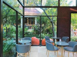 un restaurante con mesas y sillas y una gran ventana en Flora Ville-SHA PLUS en Chalong 