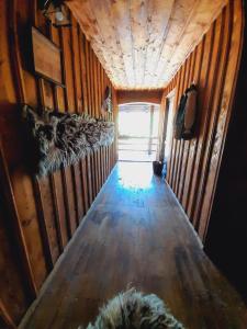 a hallway in a train car with a wooden floor at Casa de la ferma Mariuca in Berbeşti