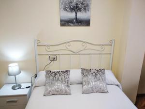 a bedroom with a white bed with two pillows at O AREAL DE NATALIA in Muxia